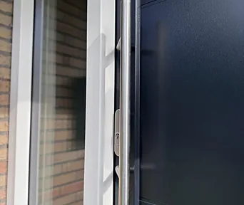 Detail van een kunststof voordeur met een rvs greep.