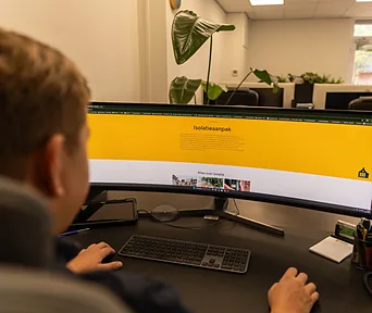 Een medewerker leest de Isolatieaanpak van Nij Begun na op het scherm.